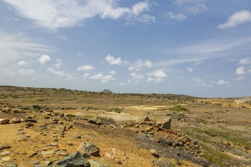 Fototapeta na wymiar Natural beauty of Aruba. North coast. Off-road Aruba. Amazing stone desert landscape and blue sky with white clouds.