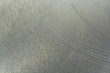 Closeup realistic gray stainless steel flat part in partial focus after industrial CNC processing at high contrast light