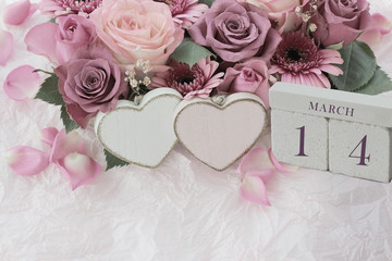 Calendar. March 14th. Wood cube calendar with date of month and day, pink flowers bouquet and two hearts. Greeting card for various holidays. Invitation. Copy space.