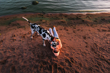 Thoughtful female owner with dog on coastline