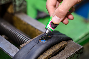 Repairing bicycle tube In workshop. Close up image of glue to repair inner tube of bicycle wheel....