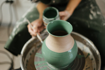 Artist painting handmade pot at ceramic workshop. Art concept. 