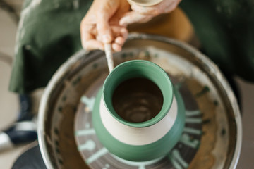 Artist painting handmade pot at ceramic workshop. Art concept. 