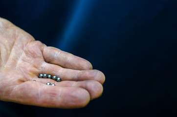 bicycle repair. Changing the lubrication and cleaning the bearings of the bike hubs. On the palm of the master are new shiny bearings. Texture of the skin close up. Hard-working hands