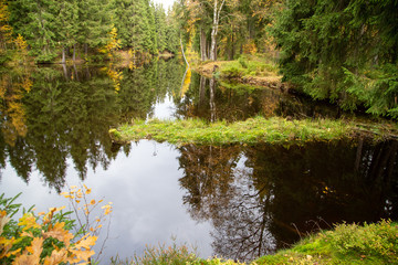 Fototapeta premium The small lake in the forest of Schoeneck in the Saxon Vogtland in autumn.