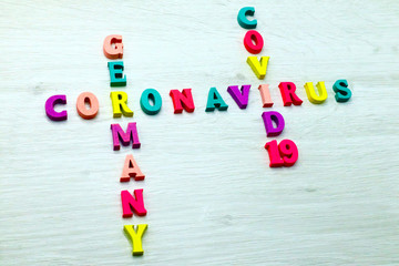 Coronavirus COVID-19 in GERMANY - Rainbow colored wood letters on grey wooden background