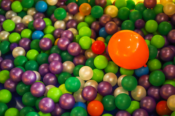 Fototapeta na wymiar Green, purple and white little balloons with a big orange ballon