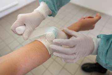 A doctor puts on a pressure bandage in a hospital