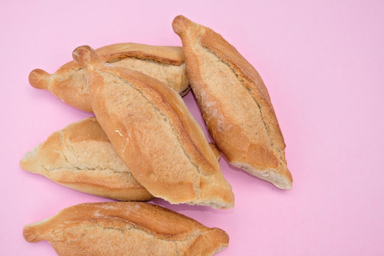 Mexican white bread, traditional Mexican baguette birote on a pastel pink background