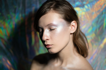 Artistic portrait of a beautiful girl with silver make-up closed eyes and dreamy facial expression....