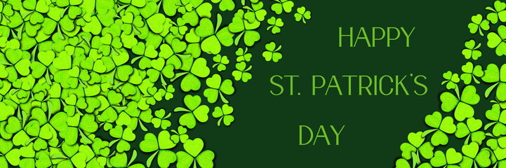 Pattern of green clovers or shamrocks on green background. St. Patrick's Day Holiday concept. Banner with text Happy St. Patrick's Day.