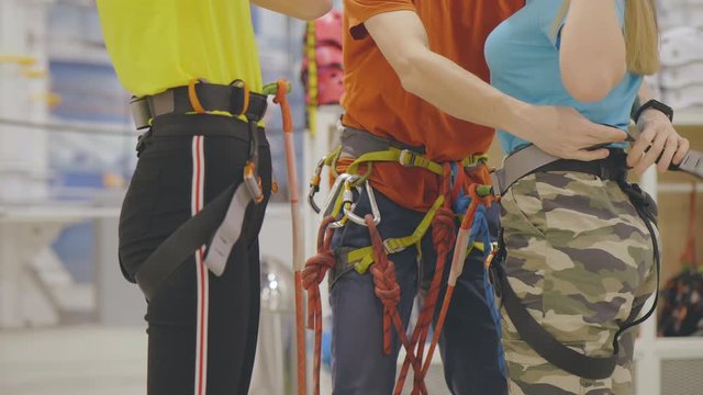 Instructor puts on climbing equipment on teenage girls