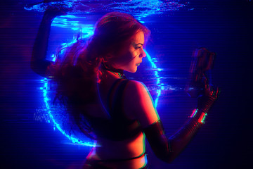 Cyberpunk style portrait of beautiful young girl poses underwater against glowing circle. Picture...