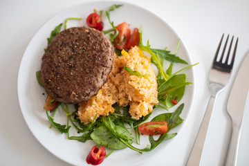 Close up of tasty patty with rice and salad on a white plate