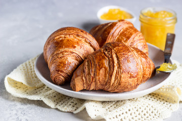Fresh croissants. Freshly baked french croissants with jam on light grey background. 