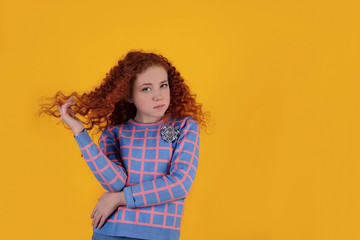 Beautiful red-haired girl on a yellow background