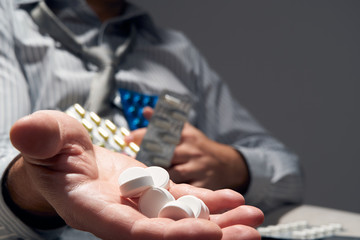 businessman with a pill, hands close view - concept of difficulties, depression, problems, health...