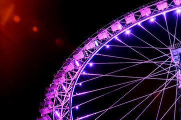 Big ferris wheel with festive purple illumination