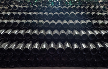 Dusty old wine bottles stacked together in a wine cellar