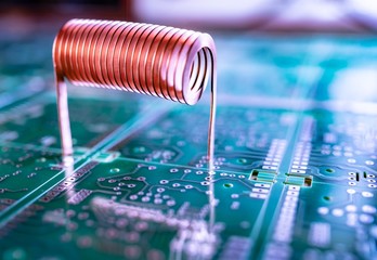 Copper wire stands on a green microcircuit