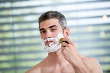 Young man shaving in the bathroom
