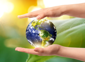 Hands of woman holding model of Earth on white background