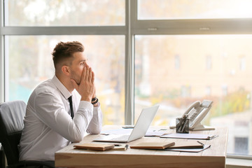 Obraz premium Tired businessman working in office