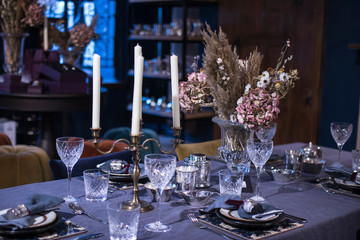 The interior of the Liberty store on Regent Street. A large table with a white tablecloth is served with china, with hydrangea flowers in large vases.