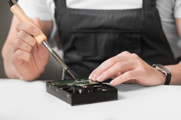 Electronic technician repairing computer in service center, closeup