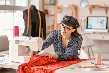 Young woman sewing clothes in atelier