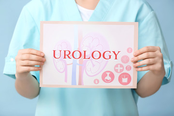 Doctor holding paper with word UROLOGY on color background
