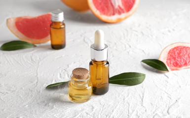 Bottles of grapefruit essential oil on table