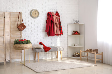 Stylish interior of modern hall with winter clothes