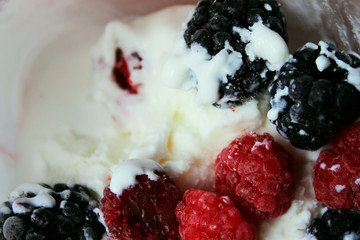 Cropped shot of an ice cream, red  raspberries and blackberry. Abstract food background.  Yogurt and berries, close up, top view.
