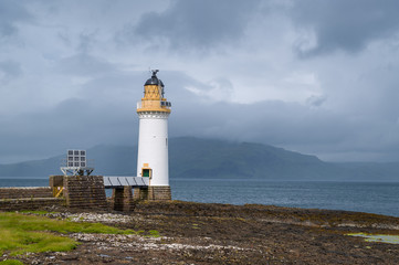 Tobermory Lighthouse and foggy view to other islands of Hebrides archipelago. Island of Mull, Scotland.