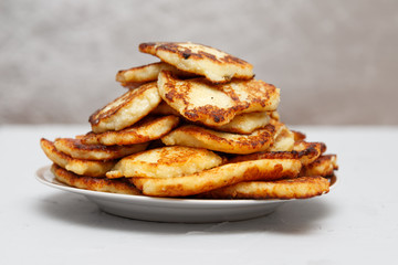 fried cottage cheese cakes on a plate on a gray background