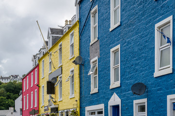 Red, yellow and blue house walls of Tobermory old town street. Island of Mull, Scotland.