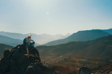 Mujer joven contemplando el horizonte en la cima de una montaña