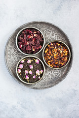 Obraz na płótnie Canvas Assortment of herbal and fruit tea in metal bowls