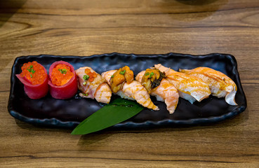 Fresh salmon sushi , salmon maki roll Japanese food restaurant, salmon sushi on plate. Sushi platter with a mixed variety of the Japanese delicacy at a buffet spread table.