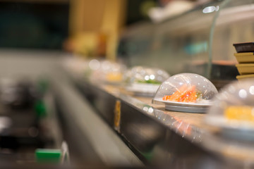 Japan restaurant sushi conveyor or belt buffet. belt sushi in japan restaurant with blurred background.