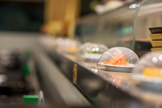 Japan restaurant sushi conveyor or belt buffet. belt sushi in japan restaurant with blurred background.