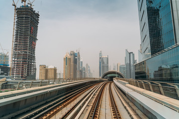 Fototapeta na wymiar Dubai metro railroad at skyscrapers buildings skyline background.