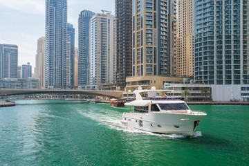 Fototapeta na wymiar Canal with boat in Dubai Marina in summer day, UAE.