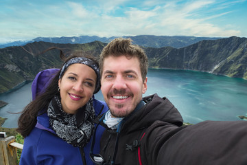 Travel couple taking a selfie at Quilotoa, lake inside a volcano in Ecuador, South America - Powered by Adobe