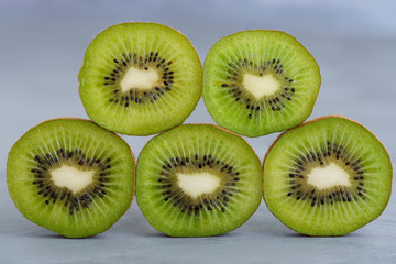 Fototapeta premium Macro shot of organic kiwi slices. Grey rustic background, high resolution