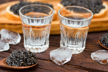 Vodka and sandwiches with black sturgeon caviar close up
