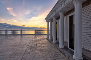 Obraz premium Beautiful building with columns on a landscaped promenade at sunset