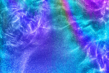 Fototapeta na wymiar Abstract neon rainbow colored glitter particles flow with shallow depth of field underwater dust. Holiday disco magic shimmering under water festive party background. de-focused.