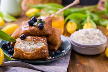 Thin pancakes with cottage cheese and strawberries. Healthy traditional breakfast concept. Baking for a traditional Russian carnival in the spring, Maslenitsa. Copy space.